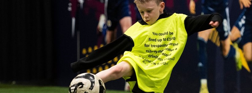 Child playing in Network Rail football camp
