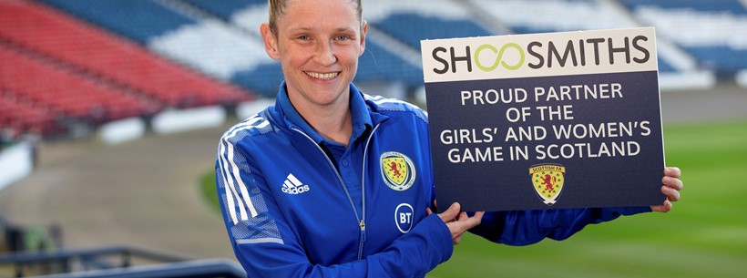 Leanne Ross holding up Shoosmiths partnership card